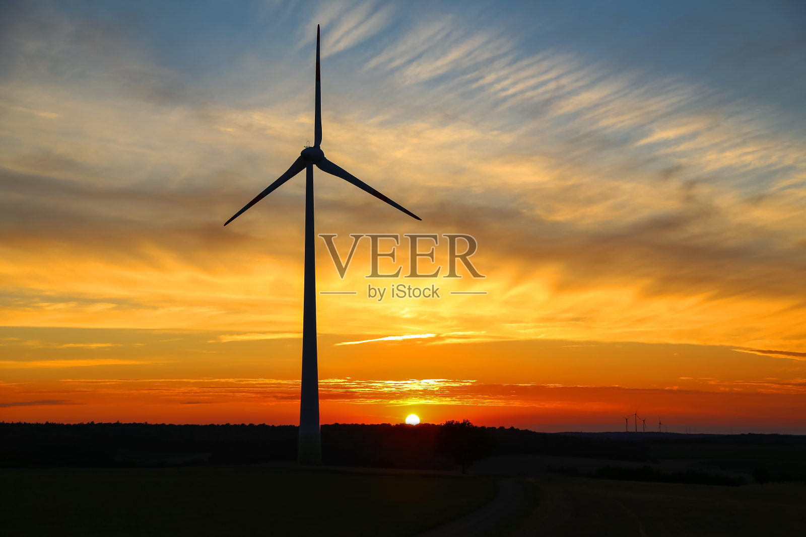 阳光明媚的日落与美丽的云彩和风车剪影照片摄影图片