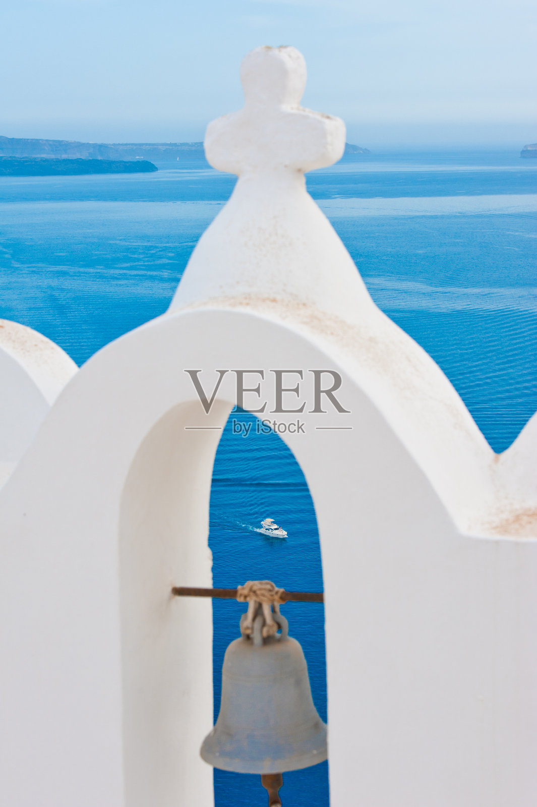 蓝色的大海和一艘游艇透过白色的希腊东正教钟楼照片摄影图片