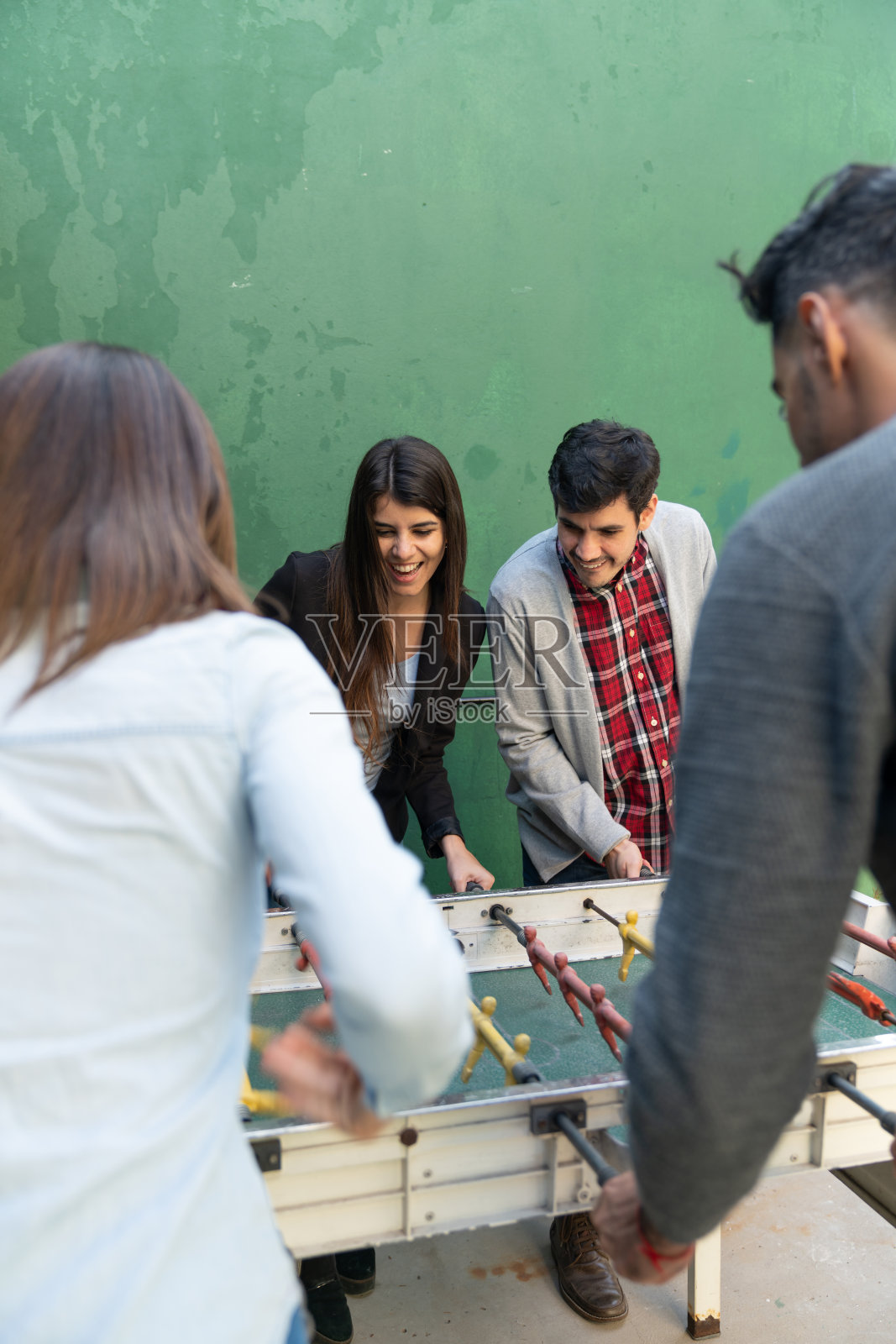 多种族的一群朋友在露天酒吧玩桌上足球照片摄影图片