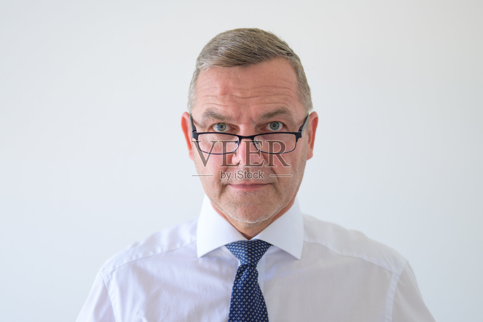 商人从眼镜上往下看照片摄影图片