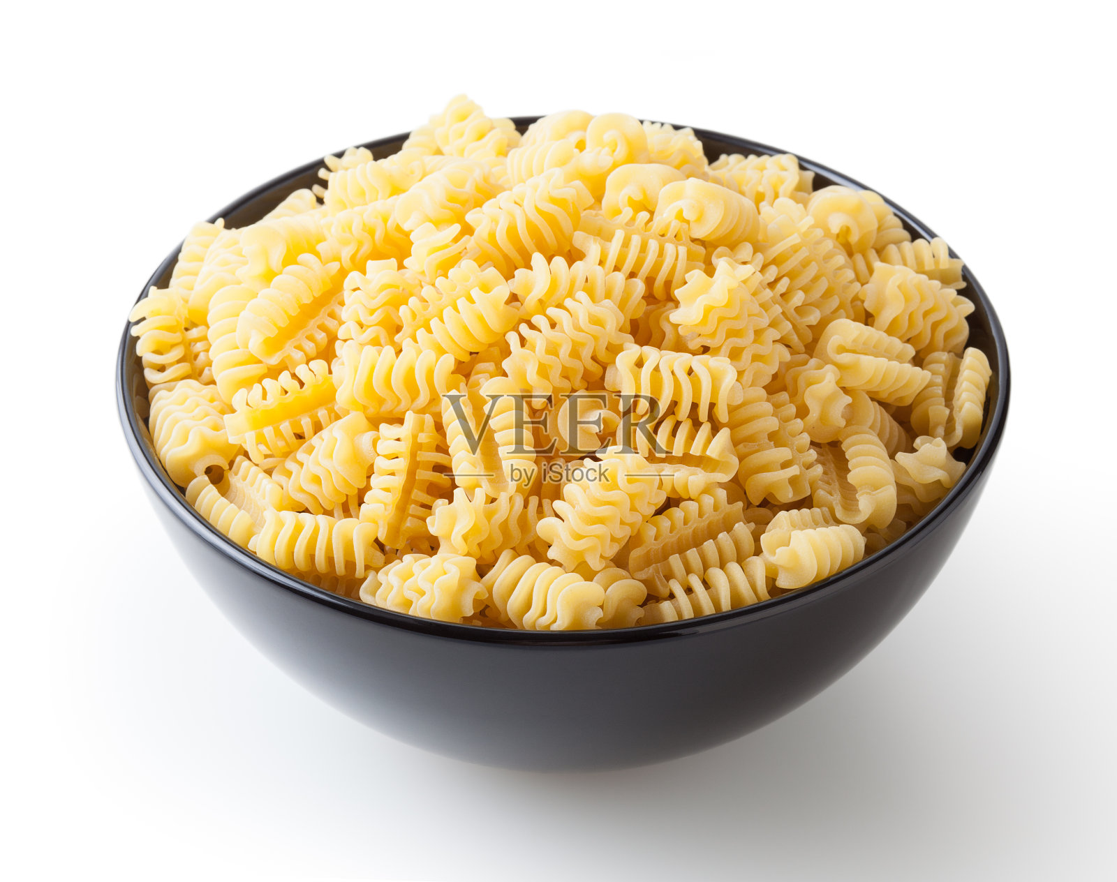 在黑色碗孤立的白色背景和剪切路径的未煮的散热器意大利面照片摄影图片