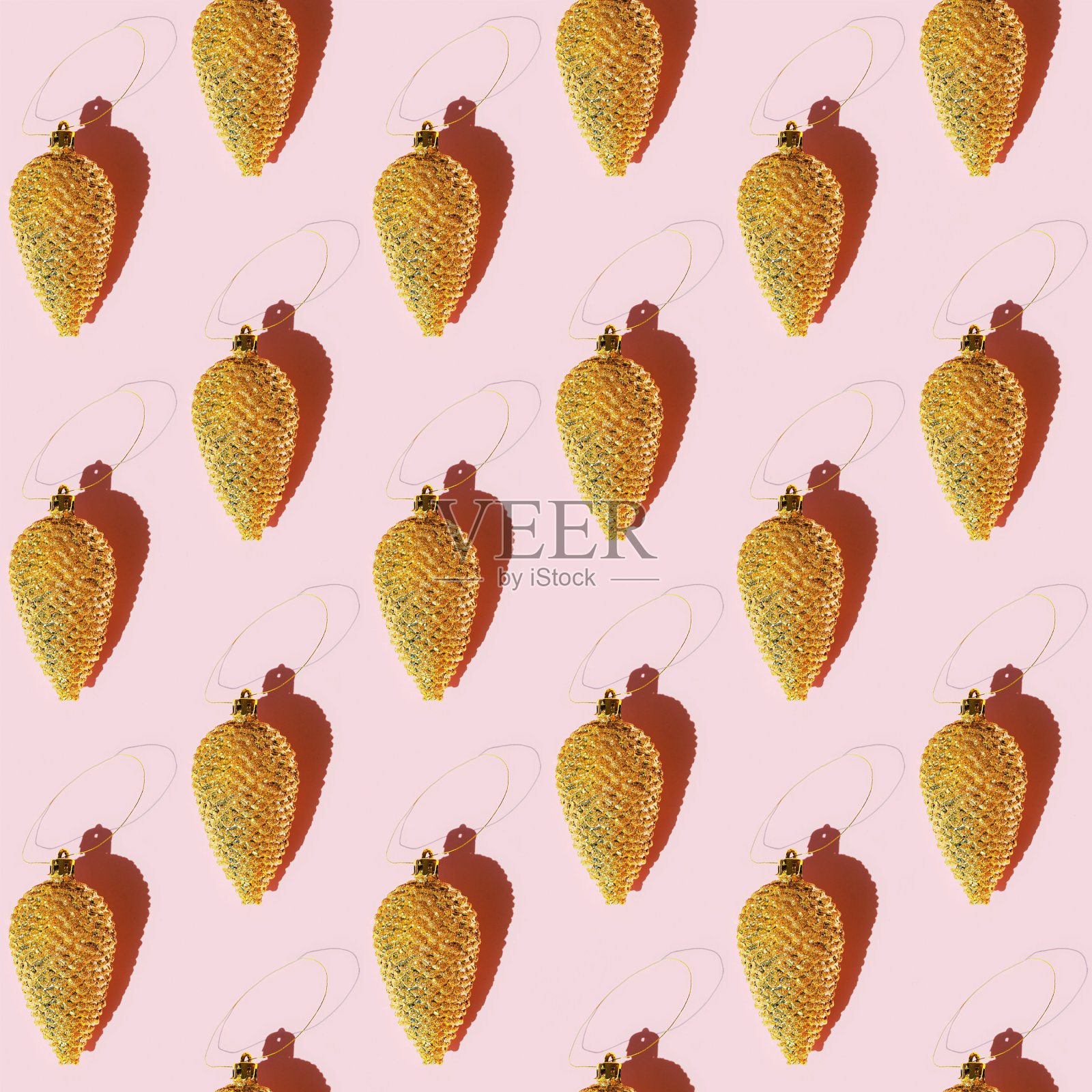 无缝规则的创意图案与碰撞圣诞金色玩具与粉色纸上的阴影。印刷织物，包装纸。照片摄影图片