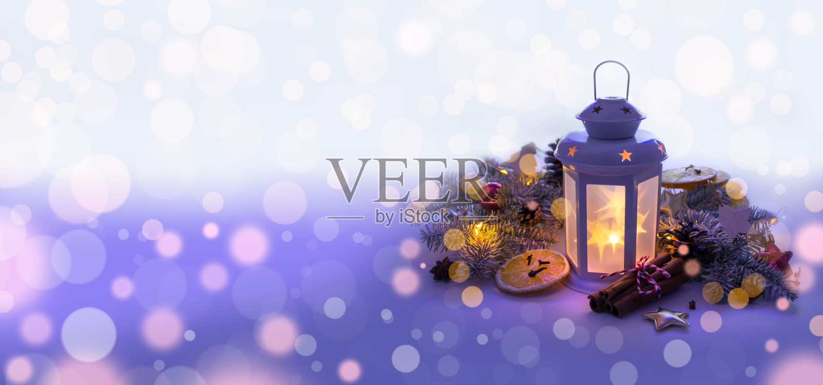 圣诞灯笼在蓝色紫罗兰背景与冷杉枝，节日装饰和花环在黑暗的光照片摄影图片