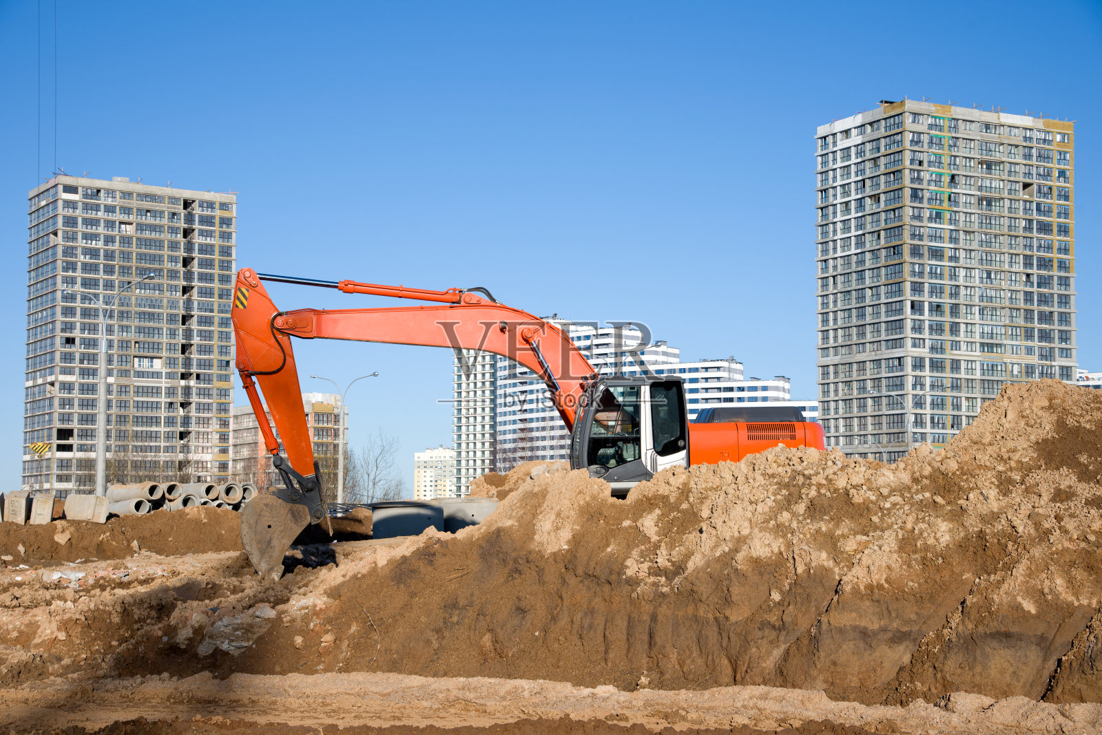 挖掘机在蓝天背景下施工现场进行土方作业照片摄影图片