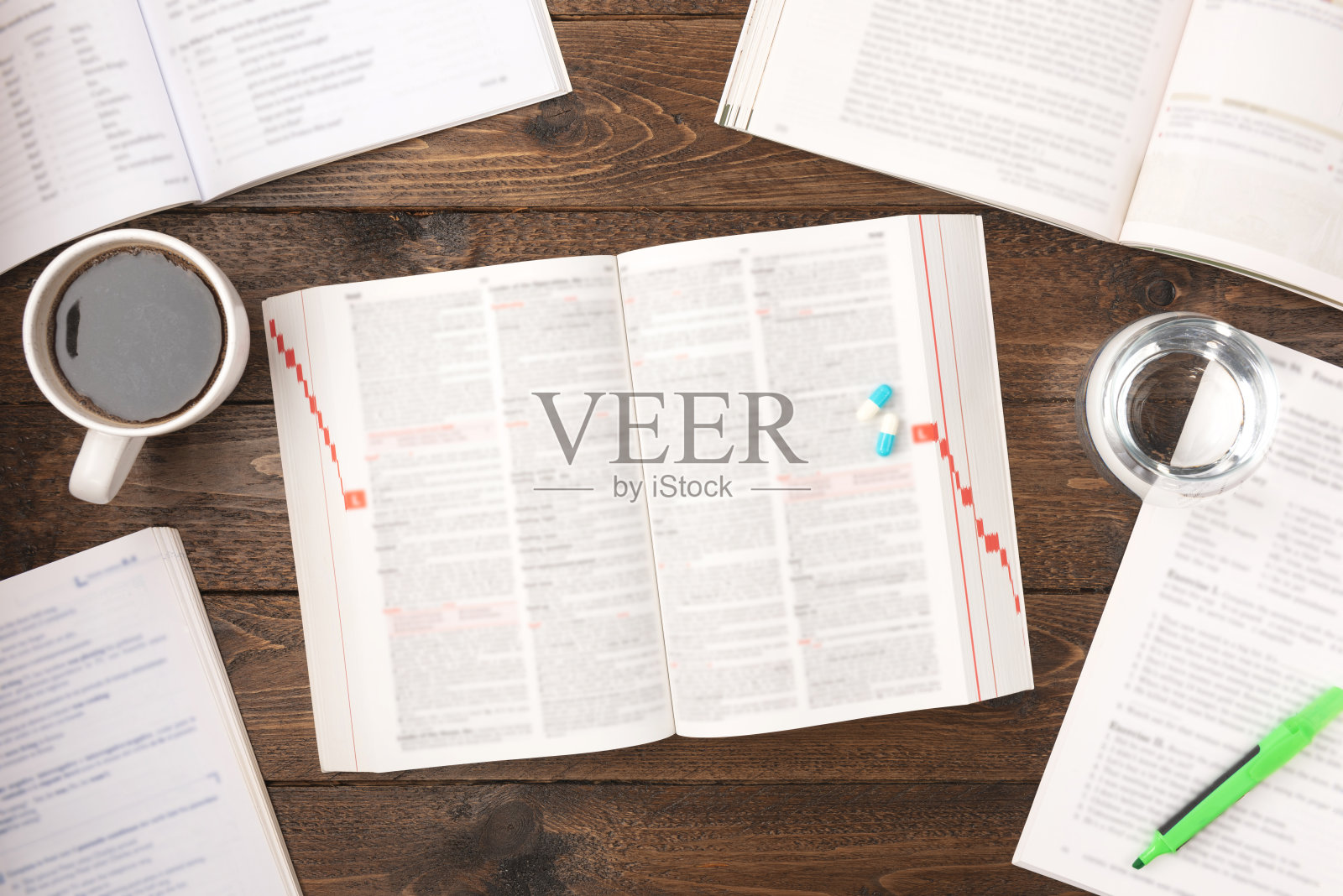 工作压力的概念。工作办公桌与药品，书籍，笔，纸，和一杯咖啡在木制的背景与复制空间照片摄影图片