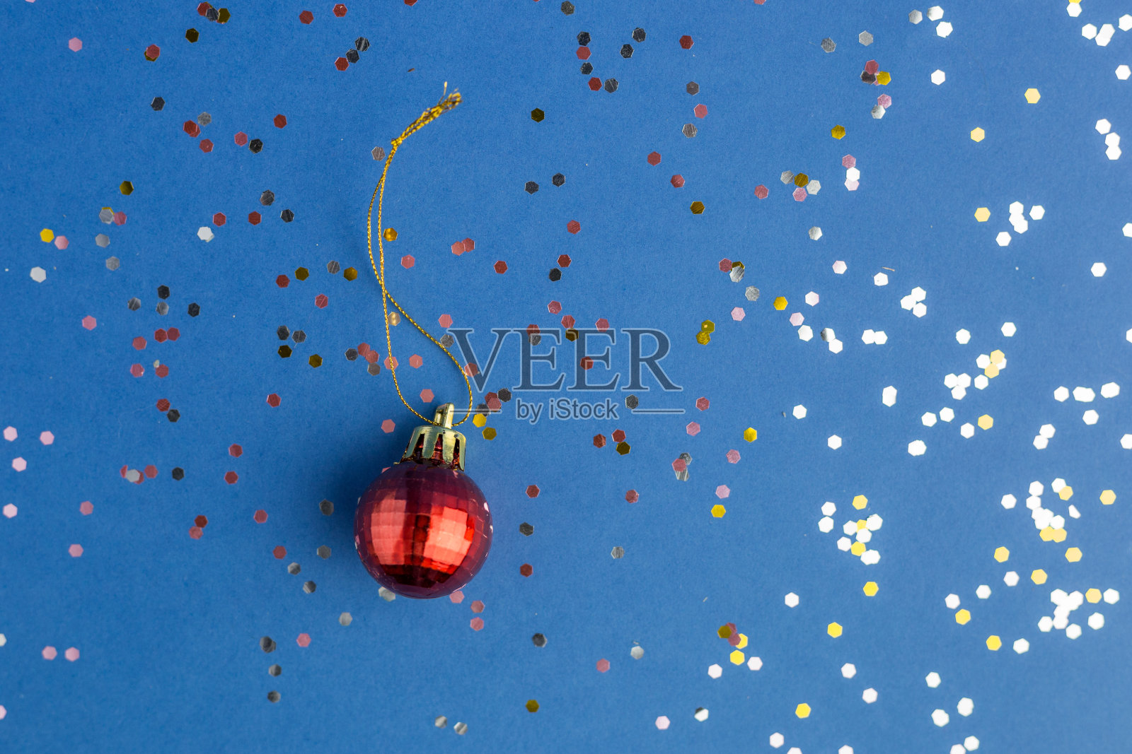 蓝色时髦的背景上点缀着红色的小玩意。节日背景的项目。平的风格。前视图。年度颜色。照片摄影图片