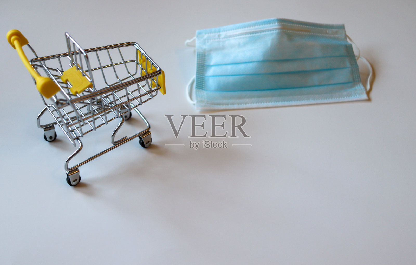装有Covid-19口罩的微型购物车照片摄影图片