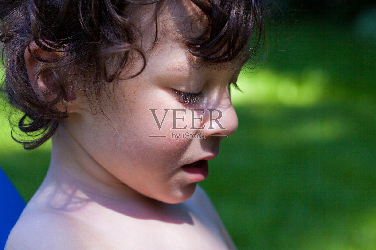 蓝眼睛的小男孩在户外看向别处照片摄影图片