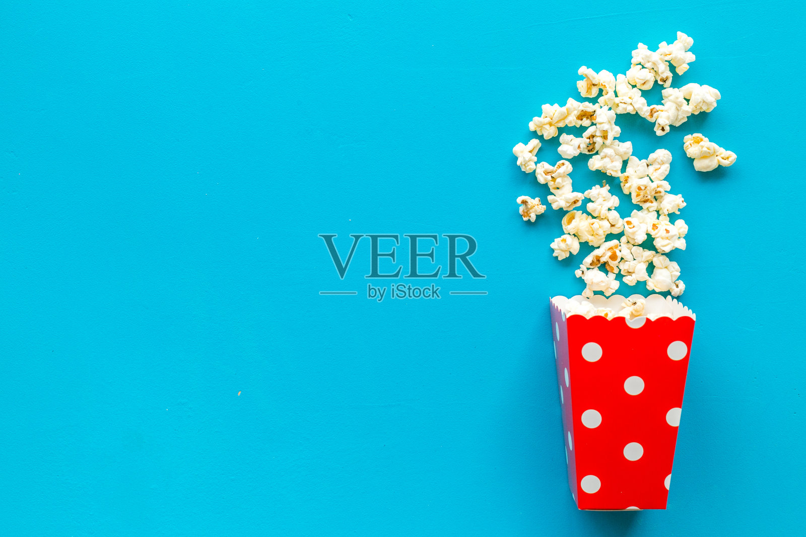 爆米花在纸杯上的蓝色桌面顶部查看空间的文本照片摄影图片