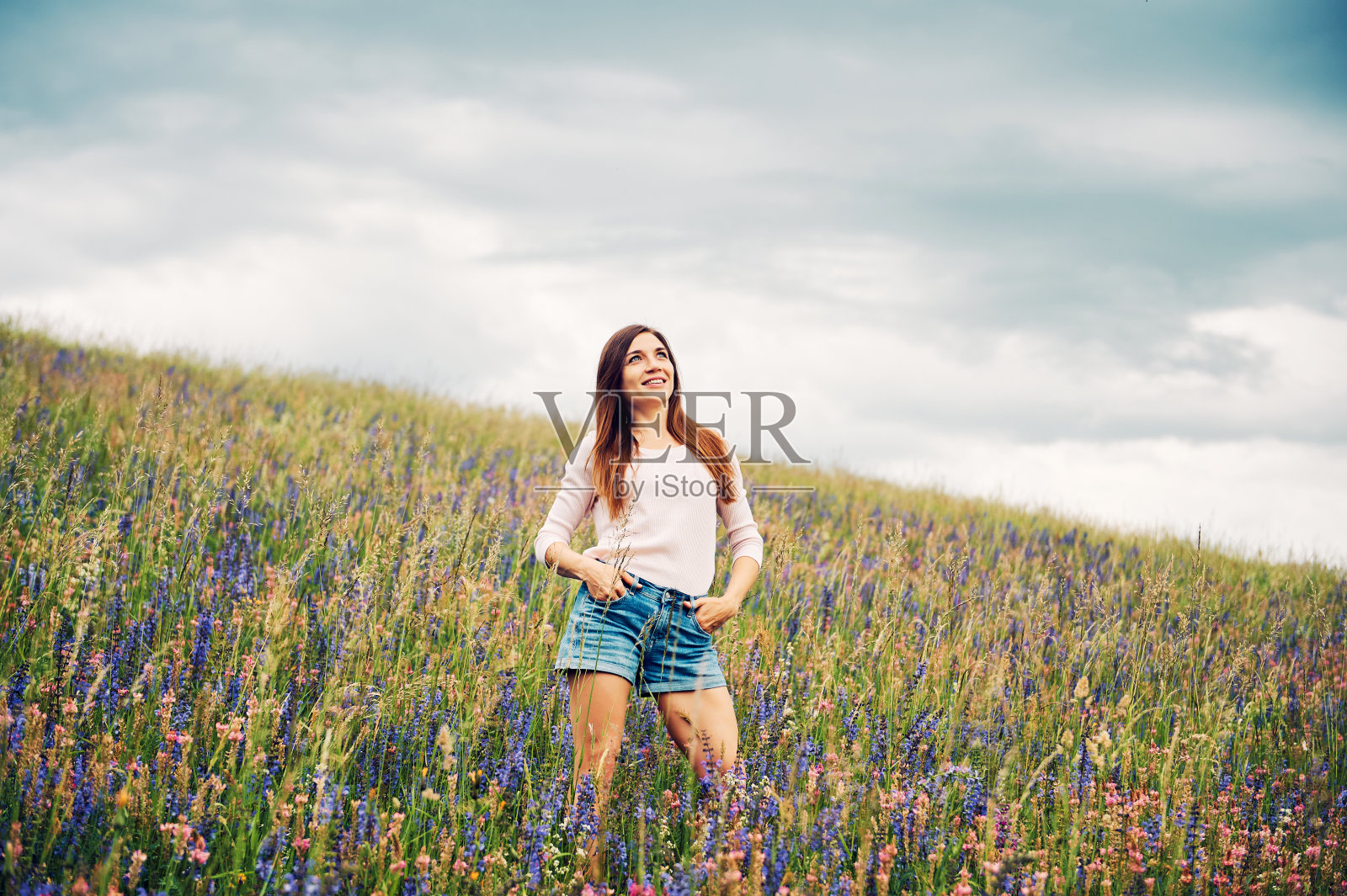 年轻漂亮的女人在野花丛中徒步旅行照片摄影图片