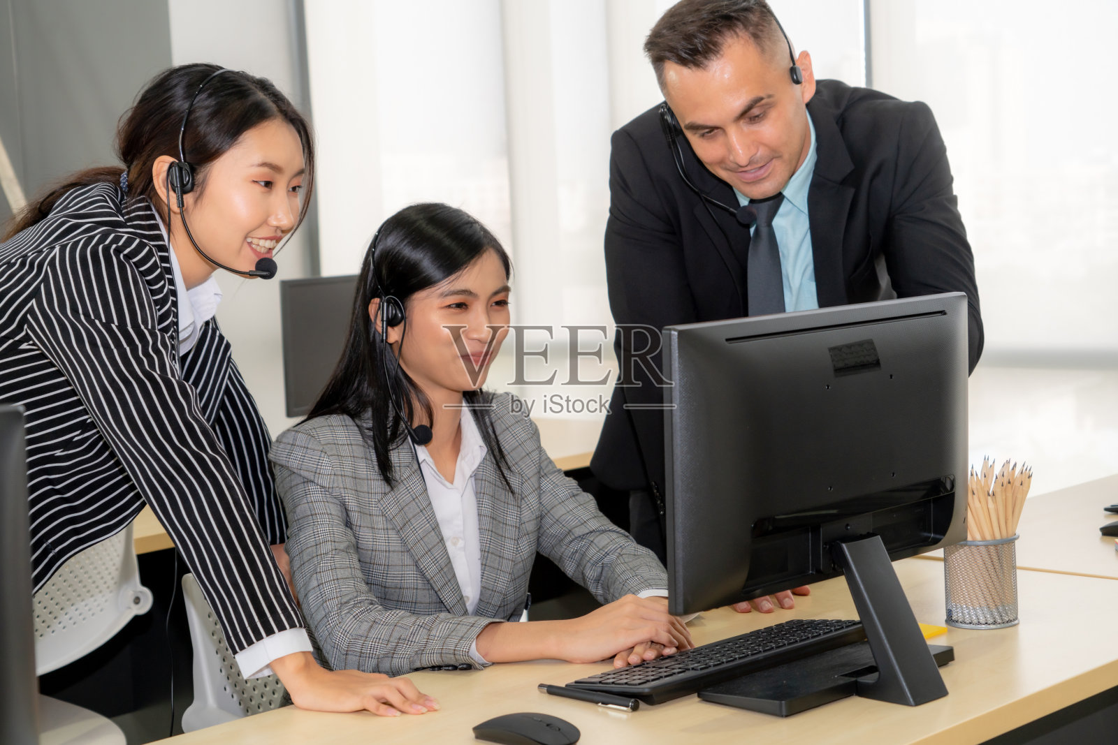 商务人员戴着耳机在办公室工作照片摄影图片