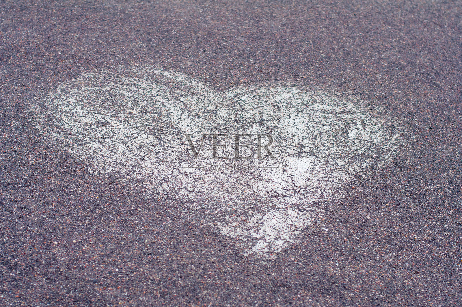 心形标志是用白漆画在柏油路上的照片摄影图片