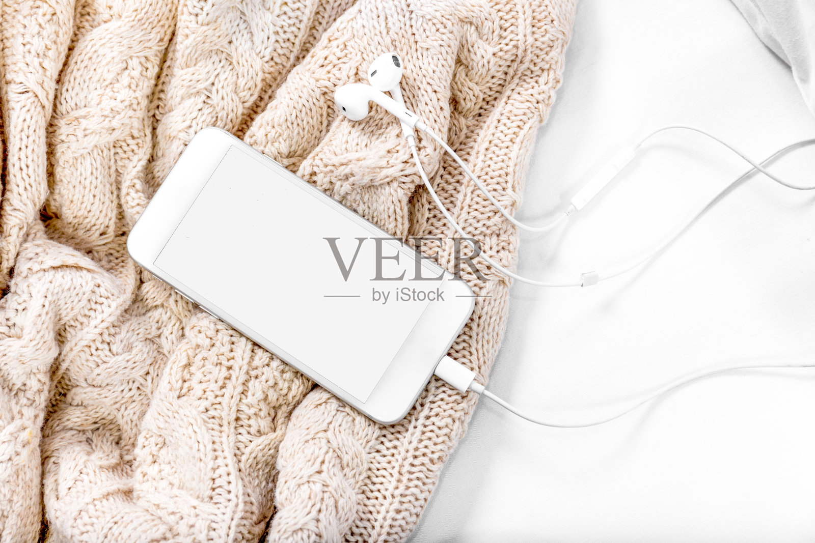床上放智能手机和毯子照片摄影图片