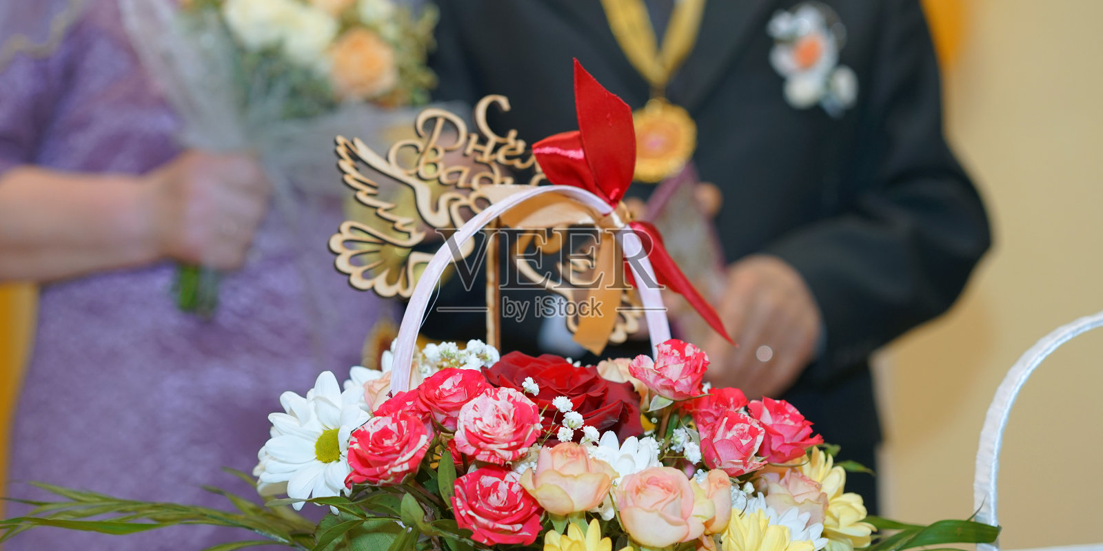 花篮与花束放在桌上，以金婚男女老人为背景照片摄影图片