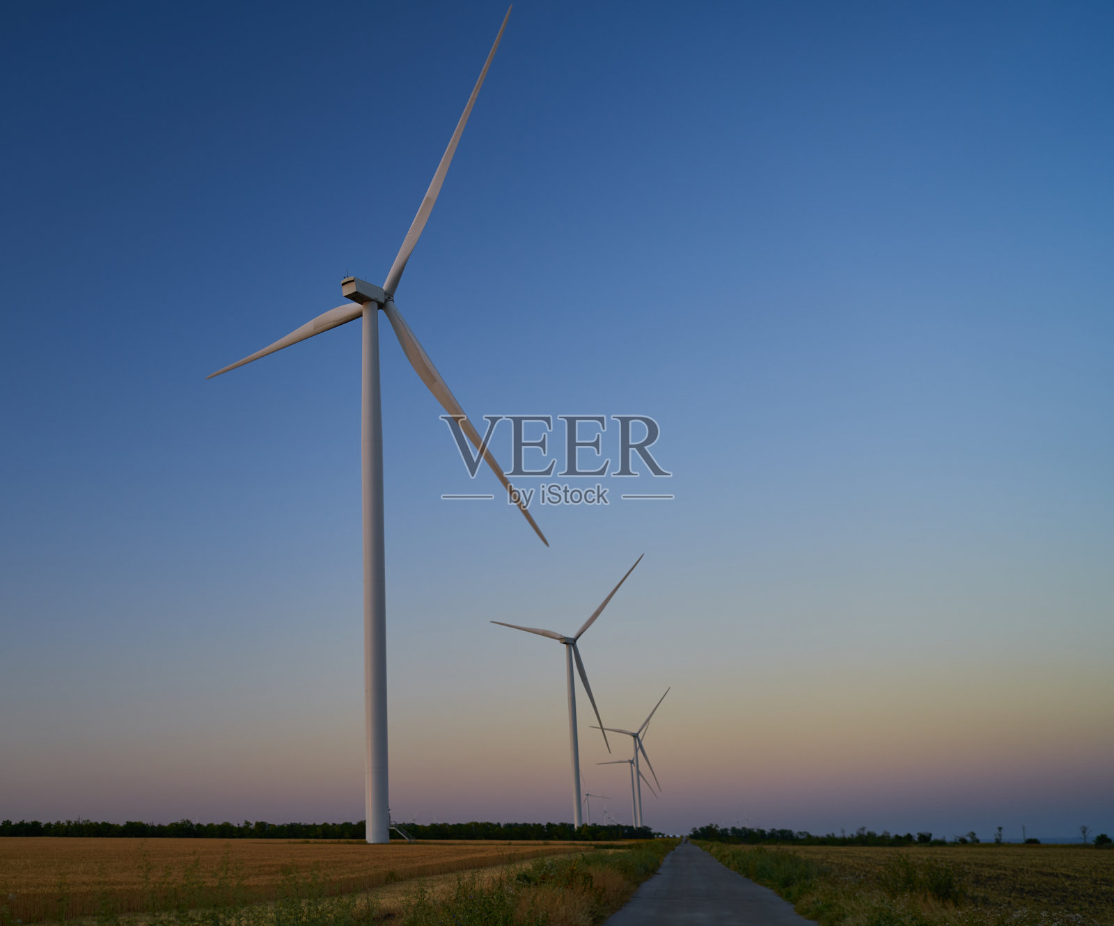 风力发电机立在田野里照片摄影图片