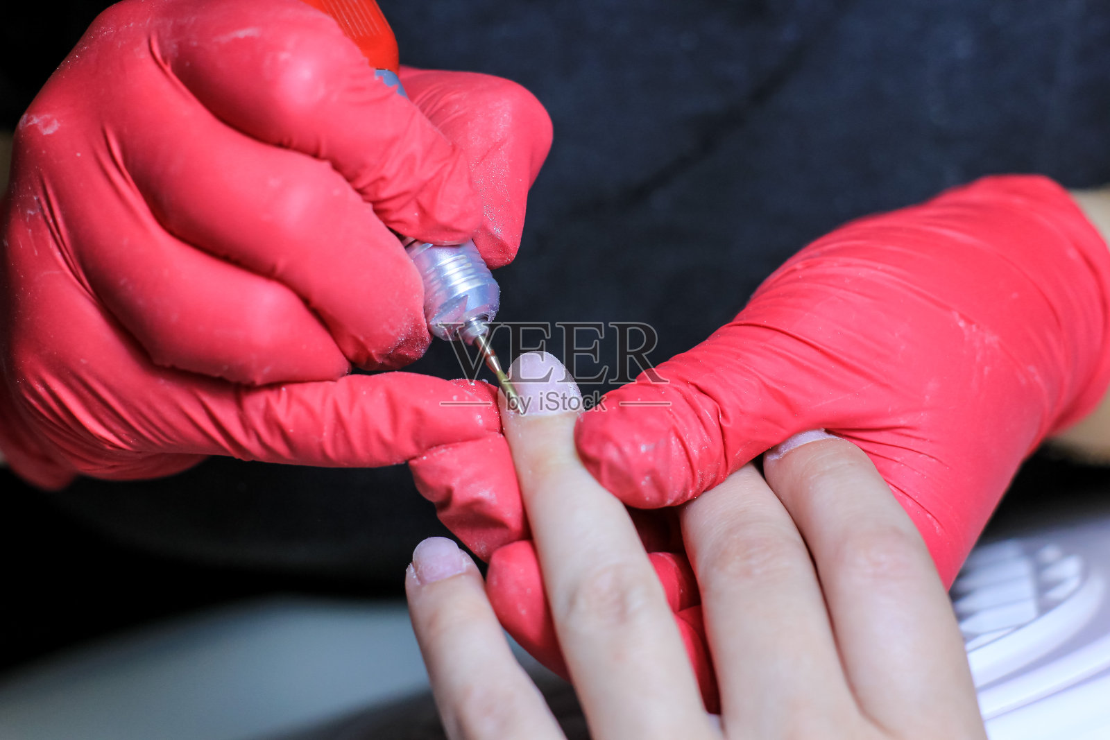 女性手在美容院专业修甲过程中，特写。美丽、健康、时尚的概念。照片摄影图片