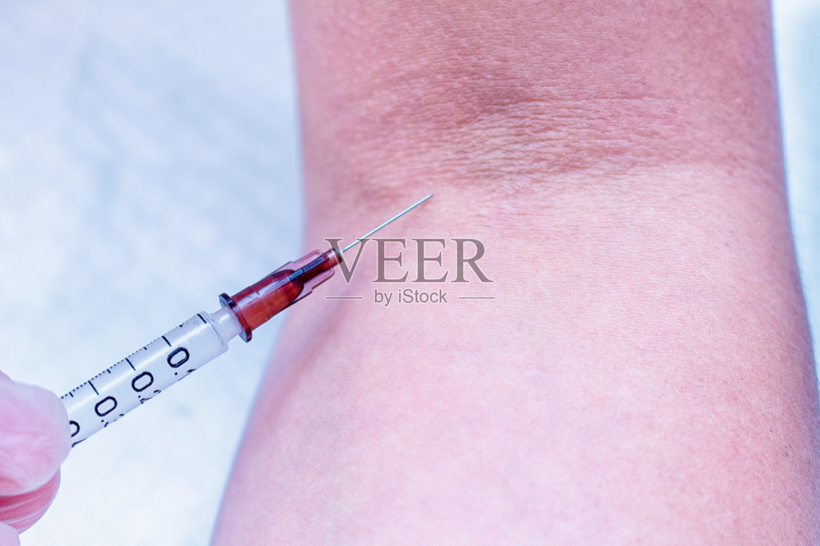 注射器注射过程中，用手拉近照片摄影图片