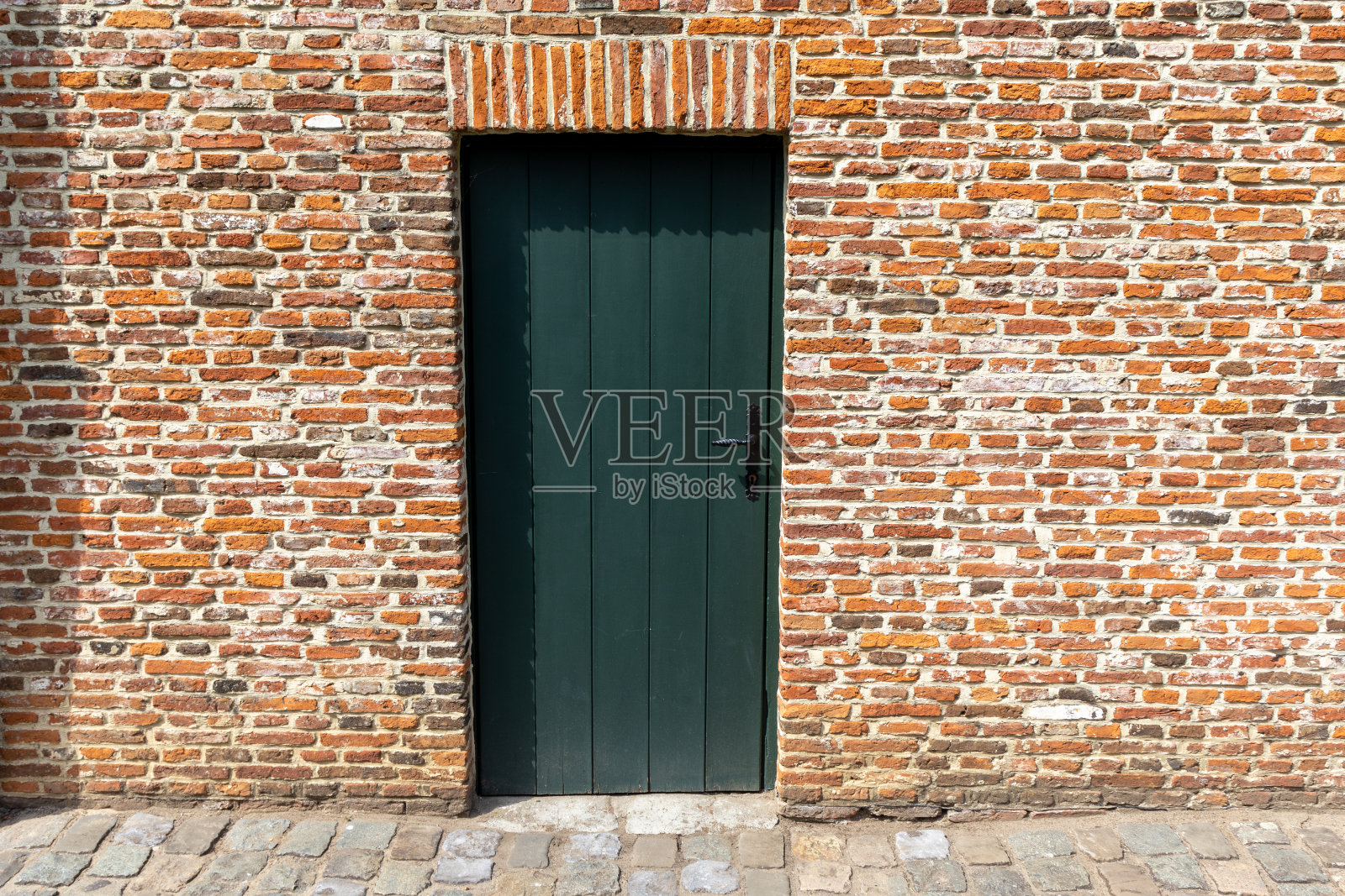 红砖墙上的一扇绿门照片摄影图片