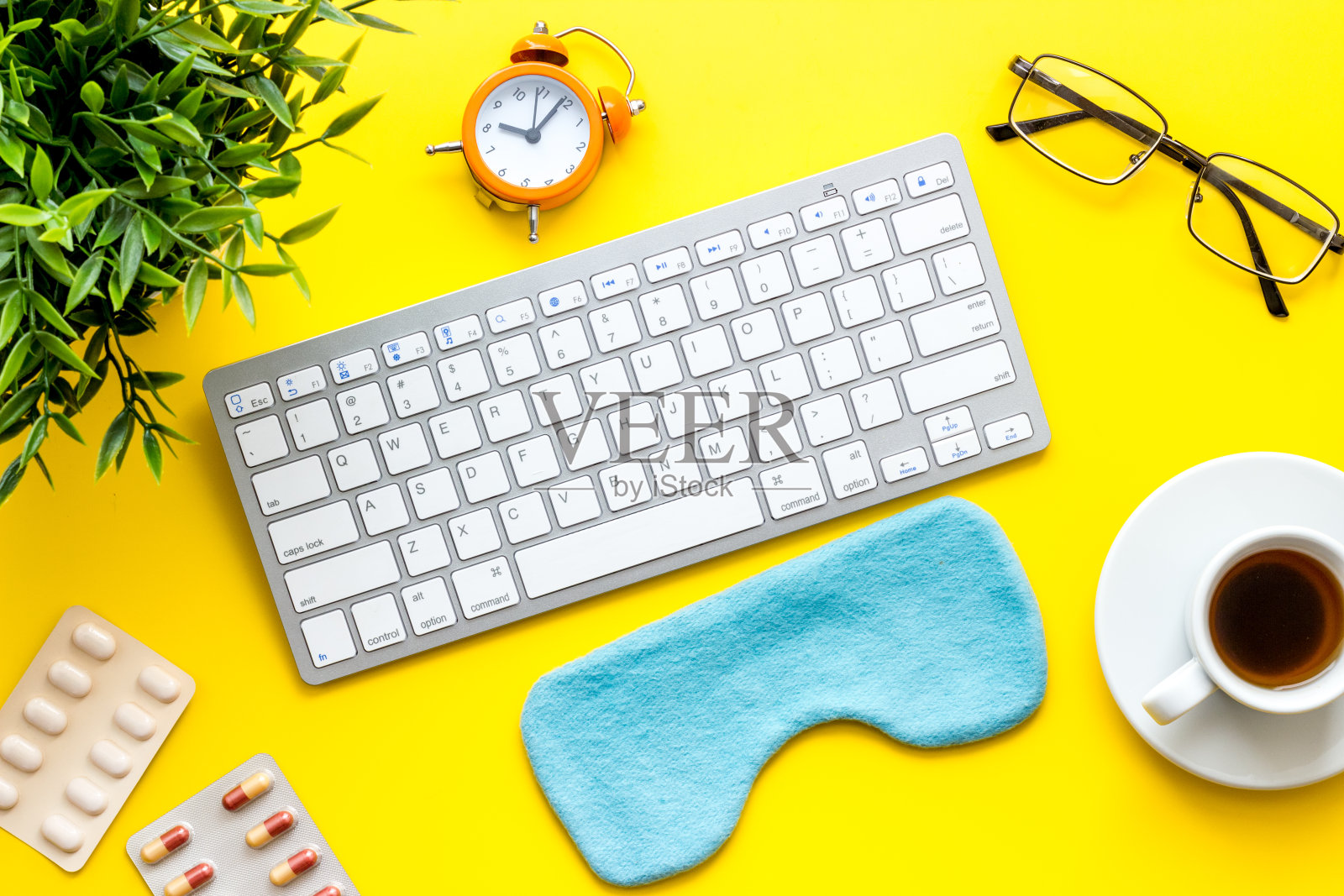 疲劳的概念。黄色办公桌上的睡眠面罩照片摄影图片