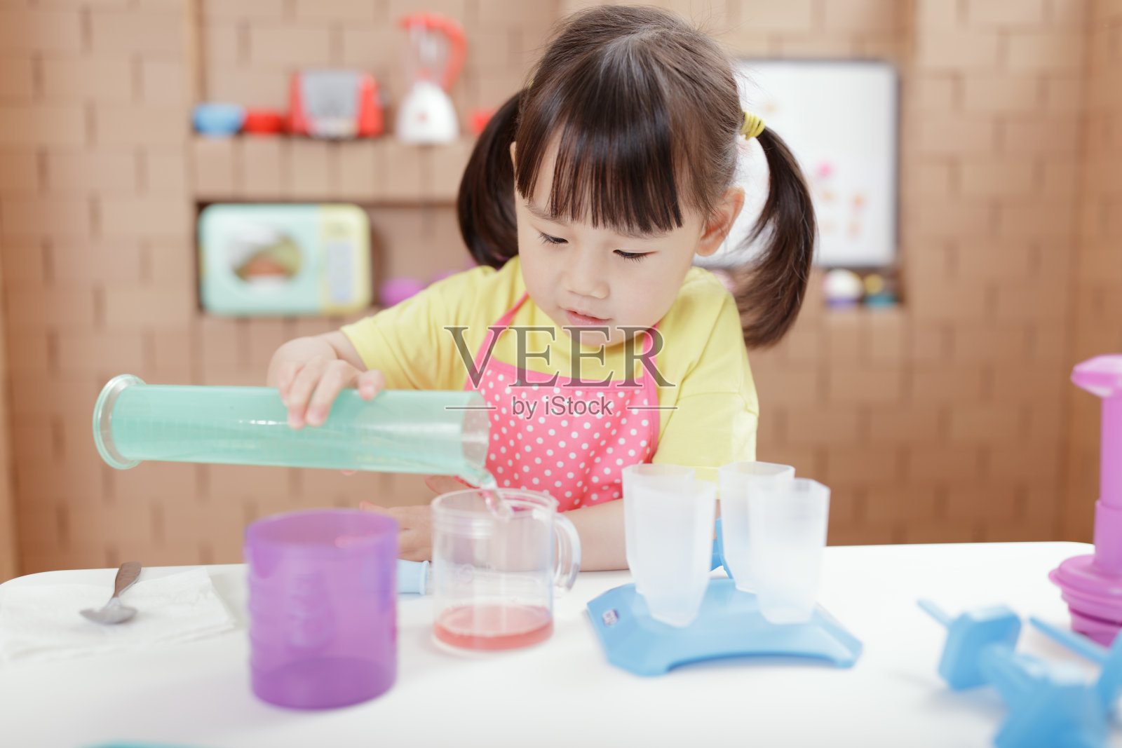 蹒跚学步的小女孩正在为家庭教育做冰棍照片摄影图片