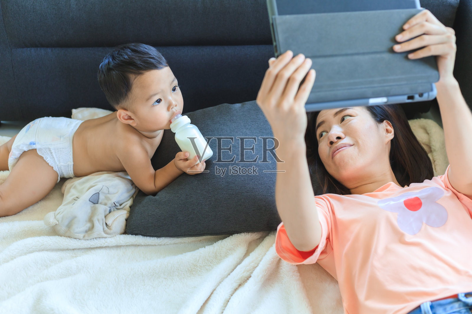 亚裔妈妈和儿子一起看平板电脑照片摄影图片