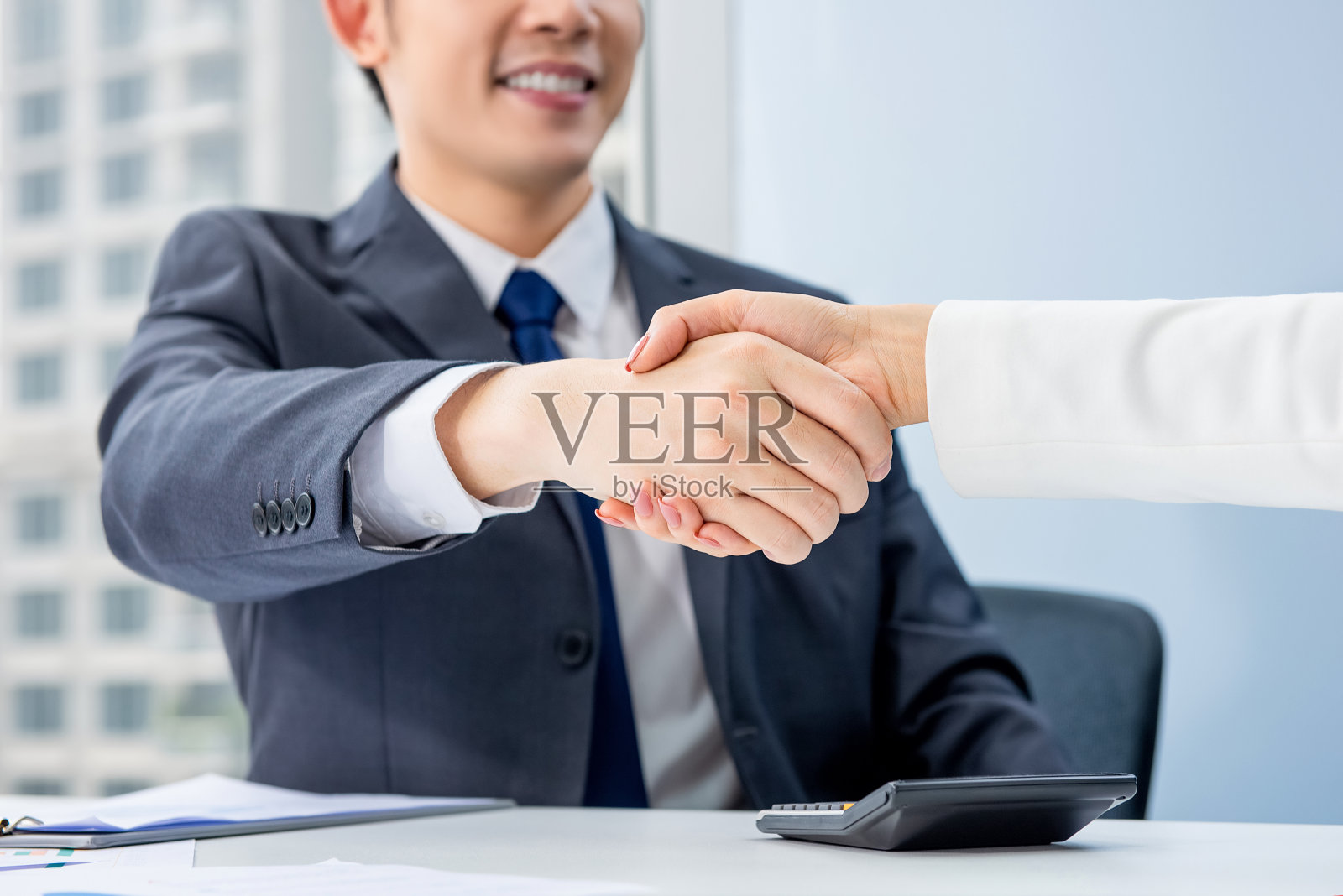 一位年轻的商人在会议上与一位女商人握手照片摄影图片