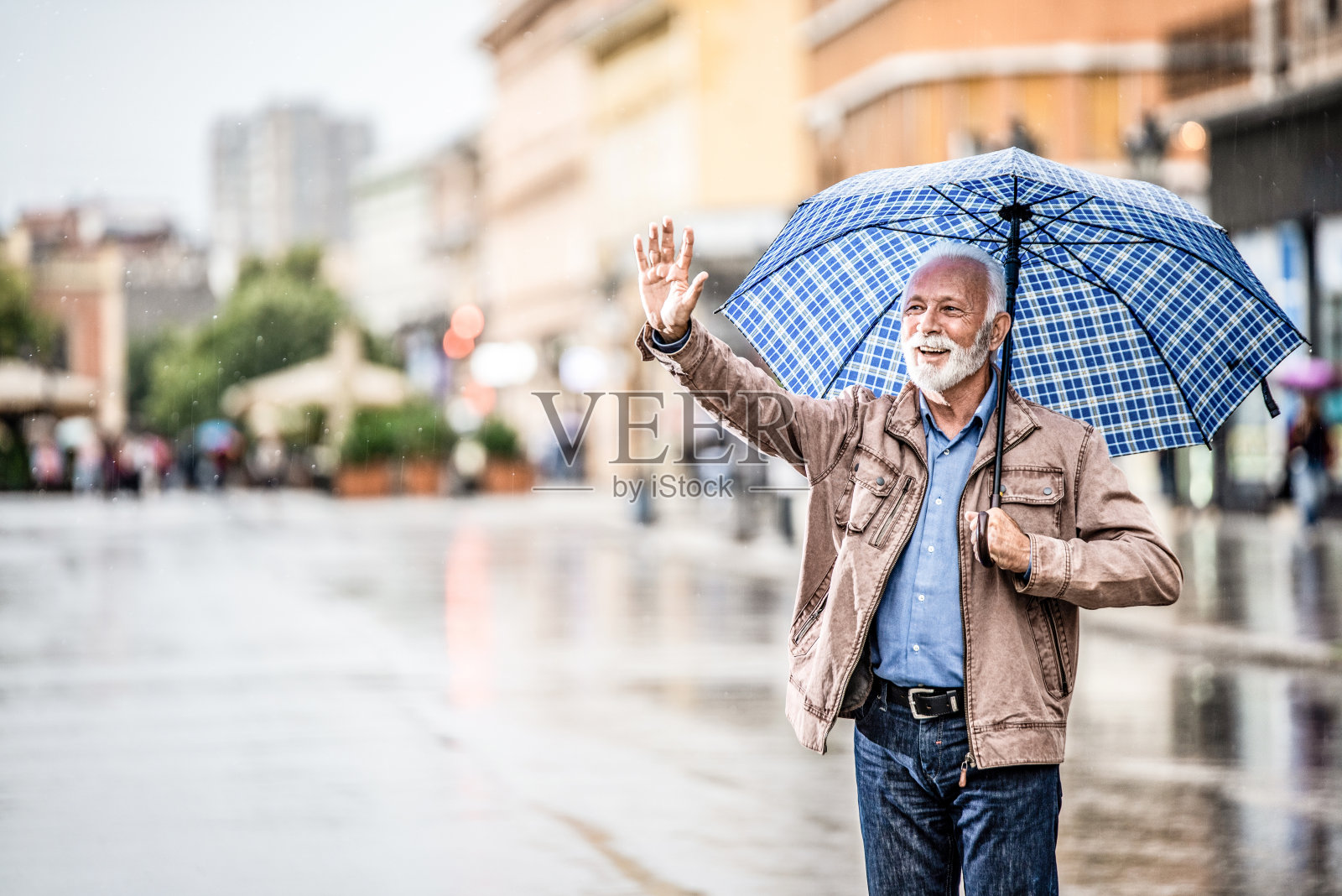 快乐的老人在雨天行走。照片摄影图片