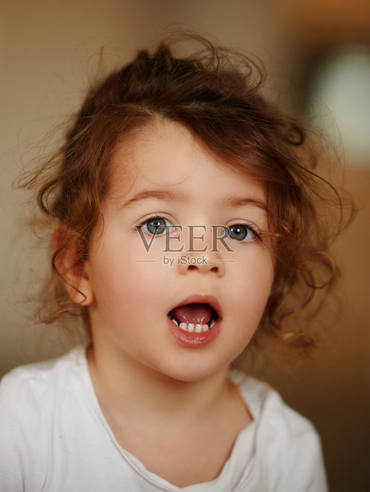 漂亮的女婴看起来很惊讶照片摄影图片