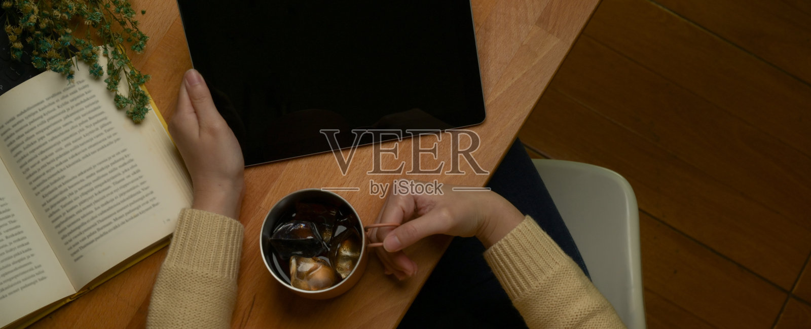 女性在阅读角放松，咖啡杯，平板电脑和书在木桌上照片摄影图片