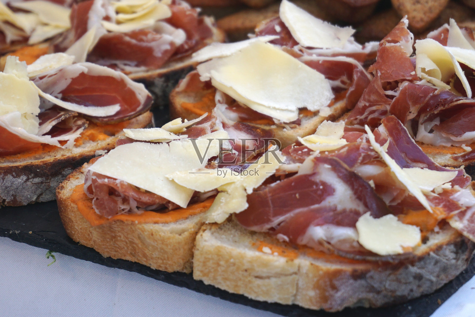 法国面包片配塞拉诺火腿，生火腿和硬芝士片照片摄影图片