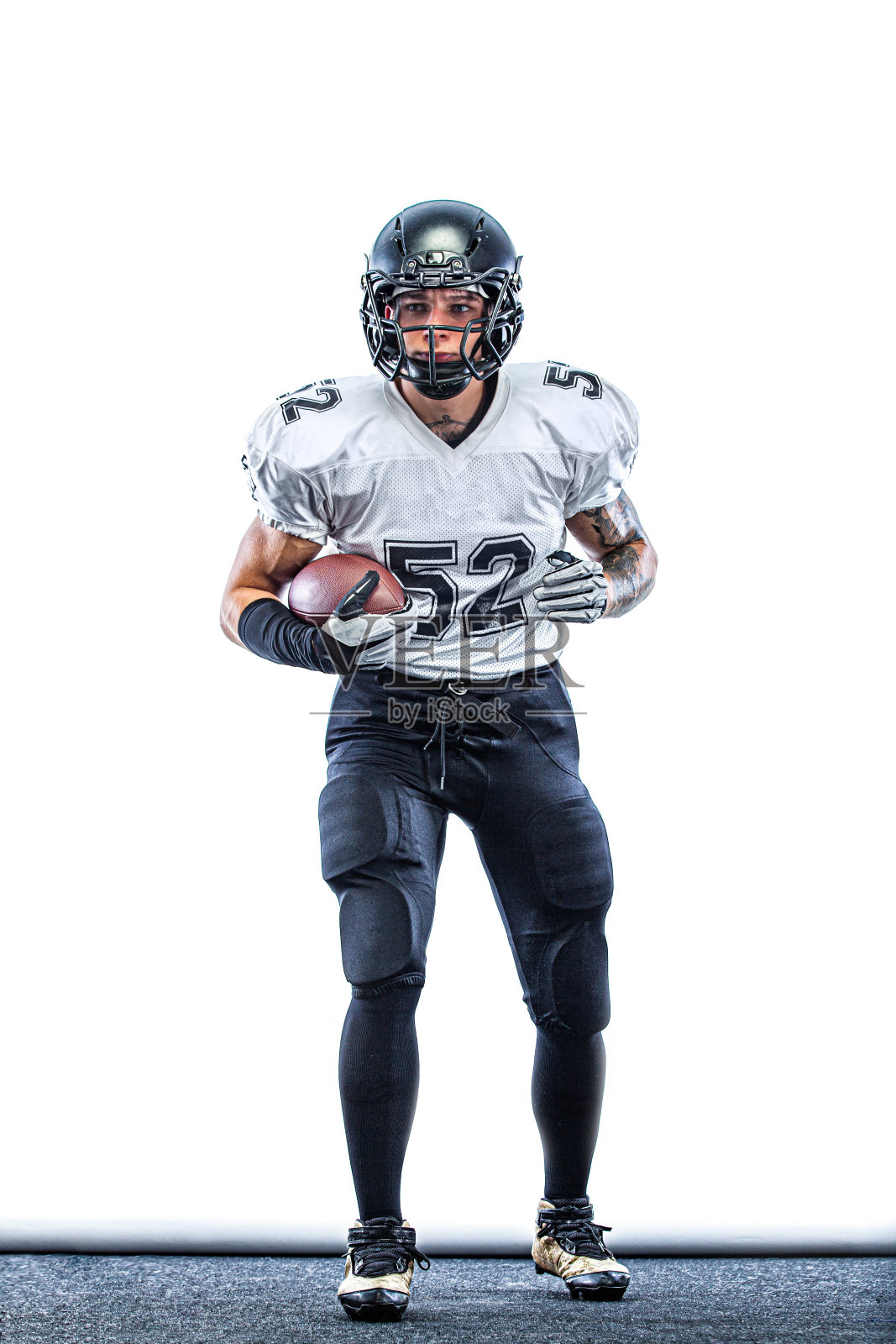 美国足球运动员。戴着头盔带球的运动员在体育场比赛。体育墙纸。团队运动。照片摄影图片