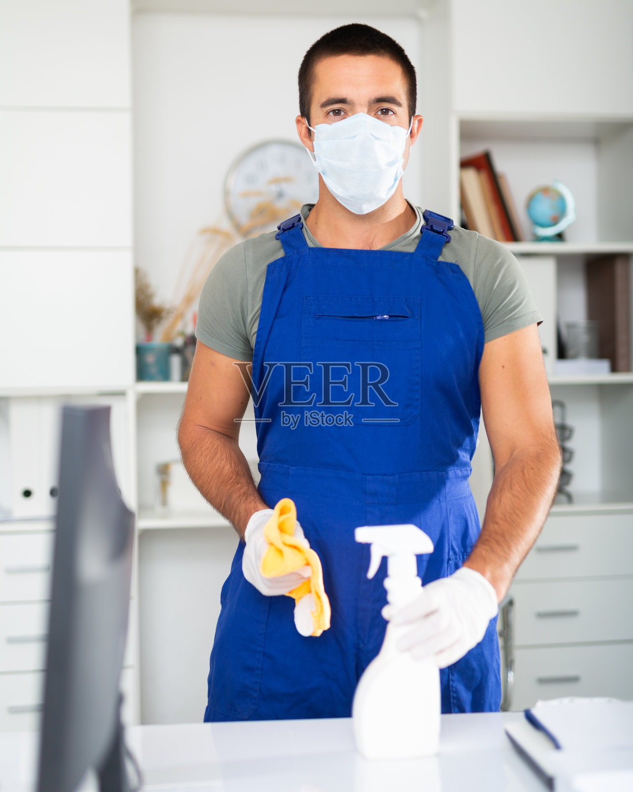 男清洁工戴医用防护口罩进行办公室清洁工作照片摄影图片