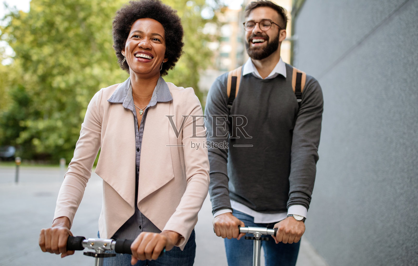 快乐的年轻夫妇享受一起在城市街道上骑电动摩托车照片摄影图片
