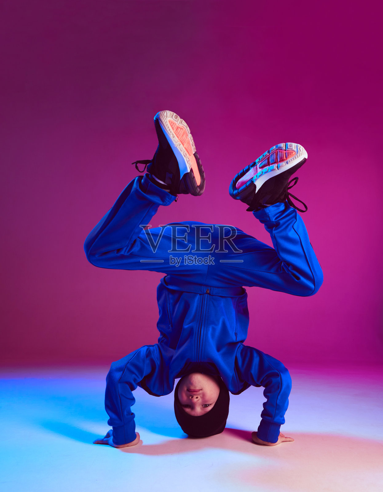 一个男孩跳着霹雳舞，在霓虹灯下跳着街舞。舞蹈学校的海报。战斗竞争声明照片摄影图片