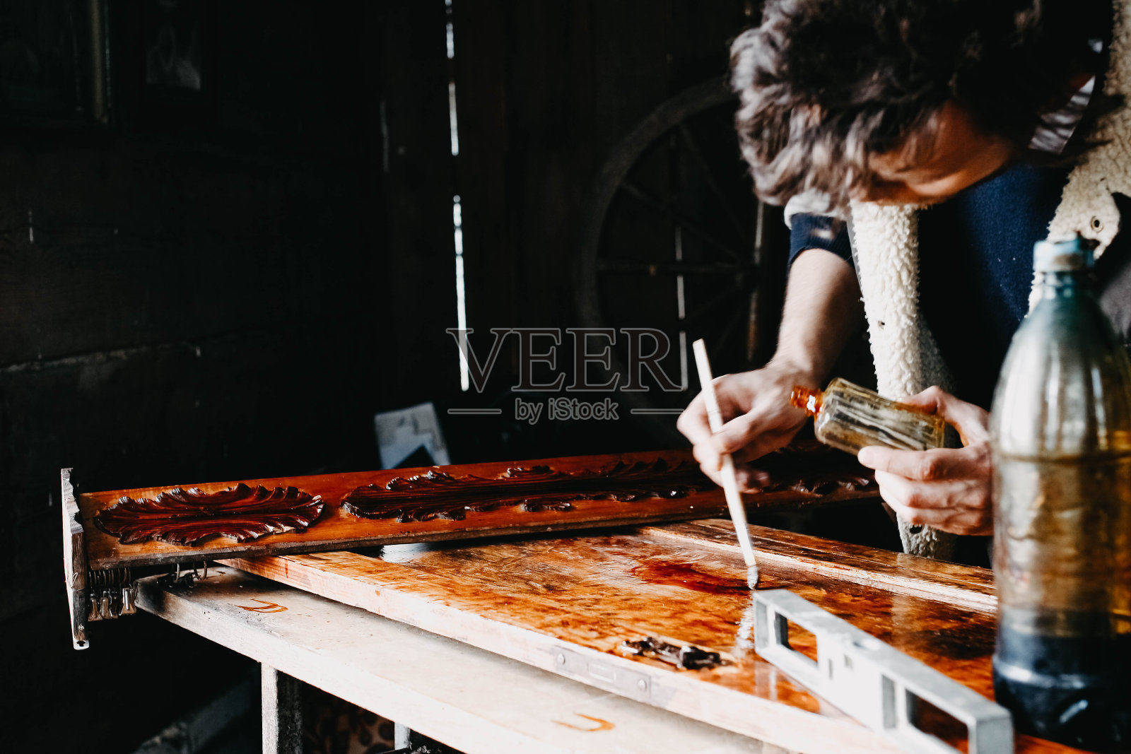 男工匠油漆实木木板，修复古董家具照片摄影图片