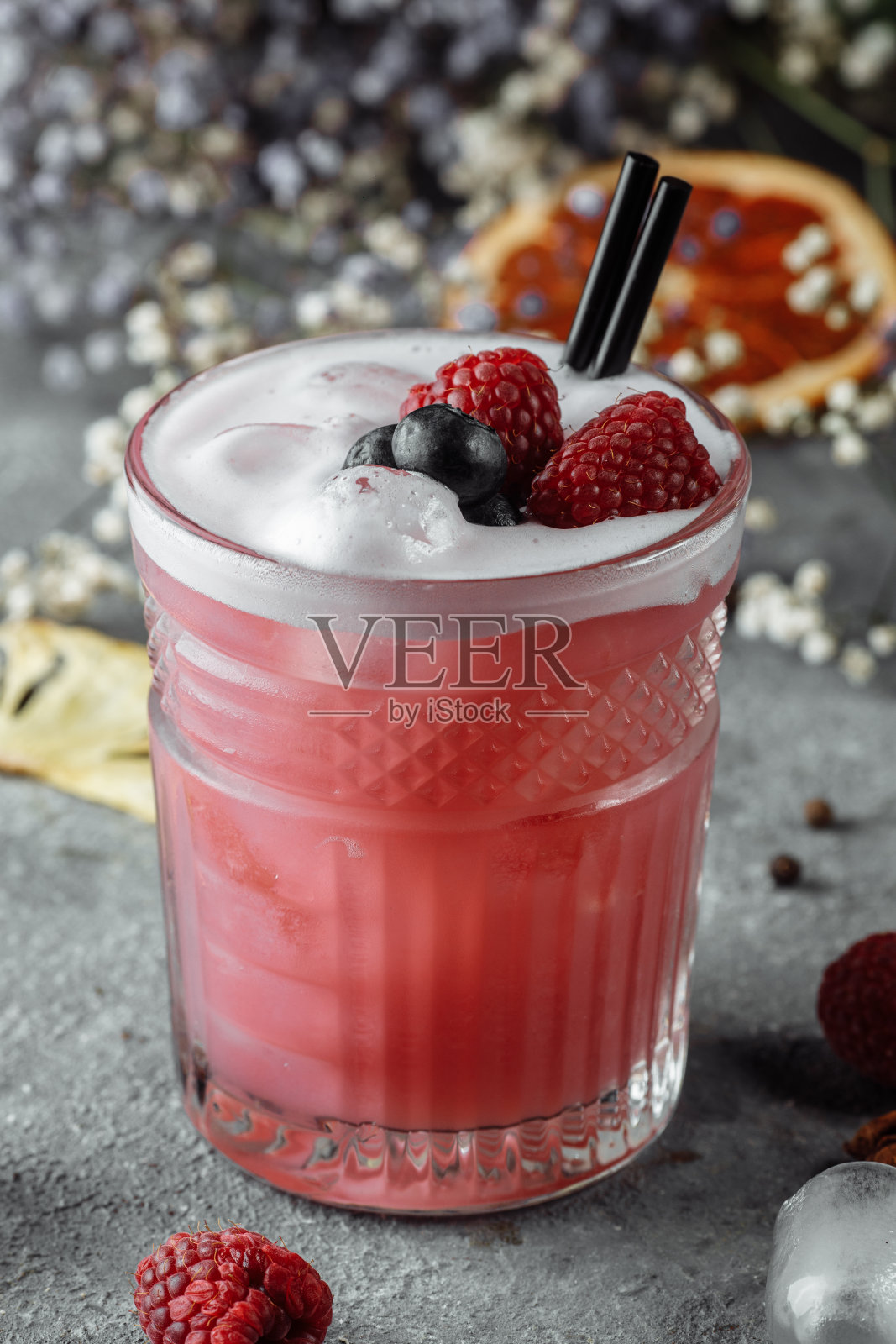 冰沙由冰冻的覆盆子，蓝莓制成。以蓝莓和覆盆子为装饰背景的鸡尾酒照片摄影图片