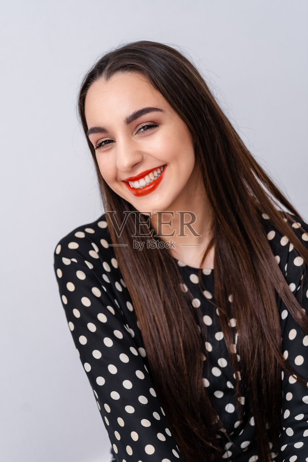 女人在镜头前露出完美的笑容和洁白的牙齿。白色背景。照片摄影图片