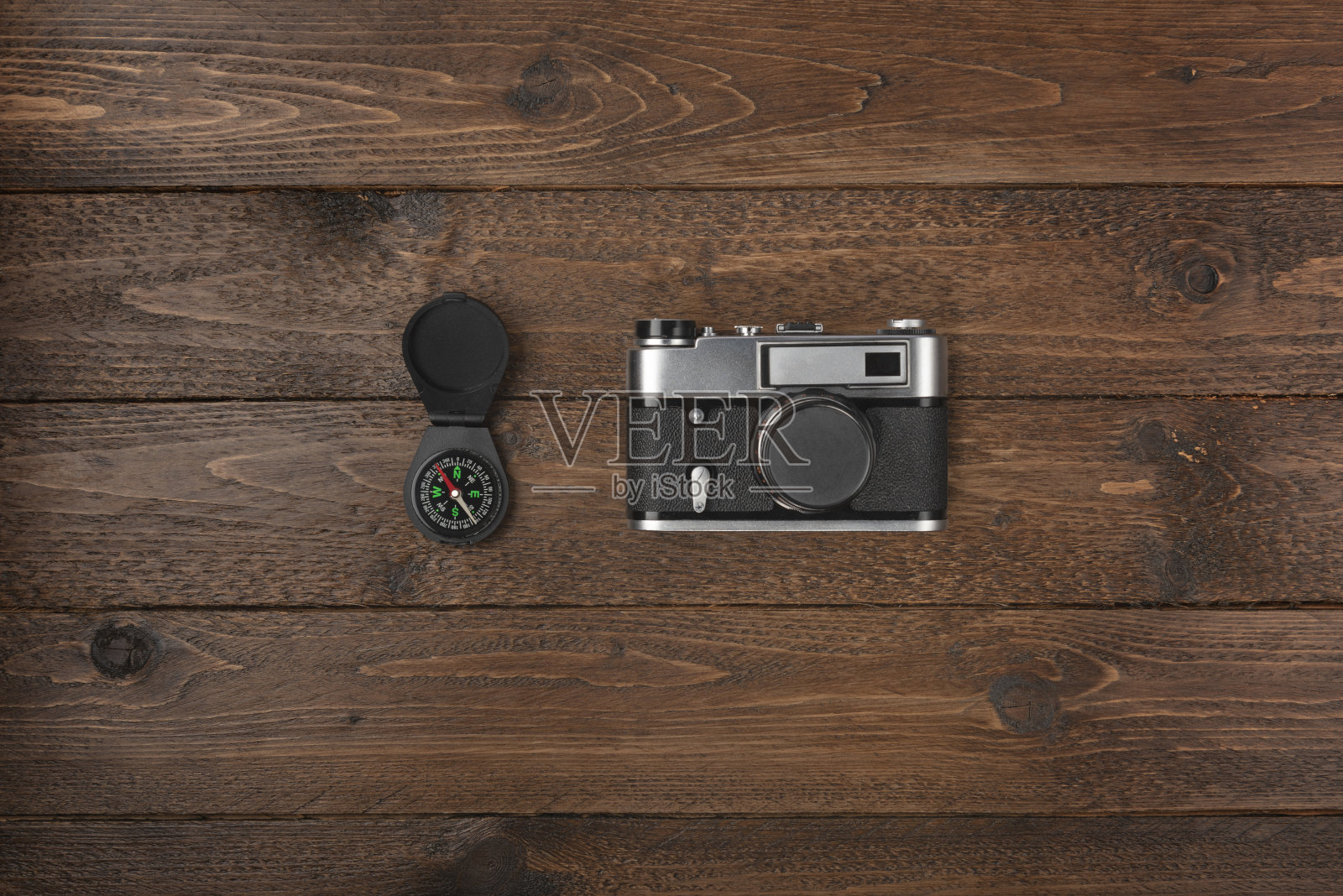 旅游的必需品。俯视图指南针和老式相机在木桌上照片摄影图片