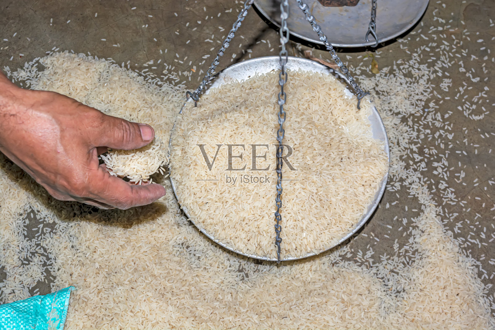 用手和旧的称重秤或平衡秤堆砌棕色米质地的背景。照片摄影图片