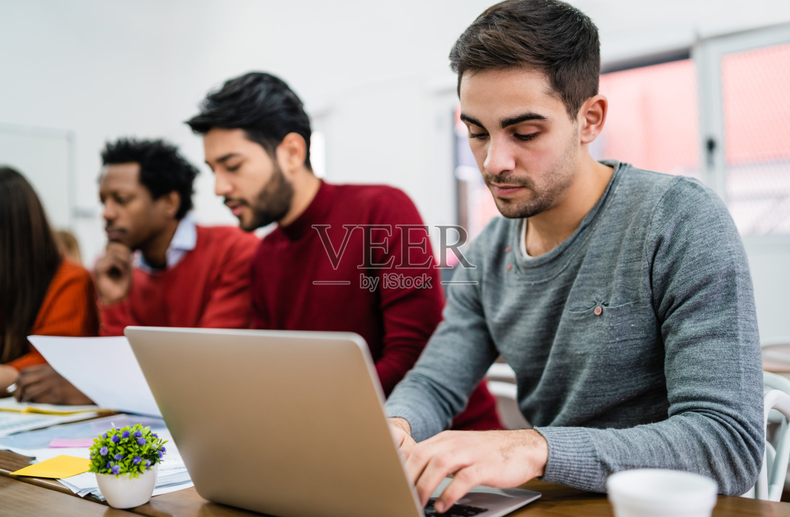 年轻有创造力的人用笔记本电脑工作。照片摄影图片