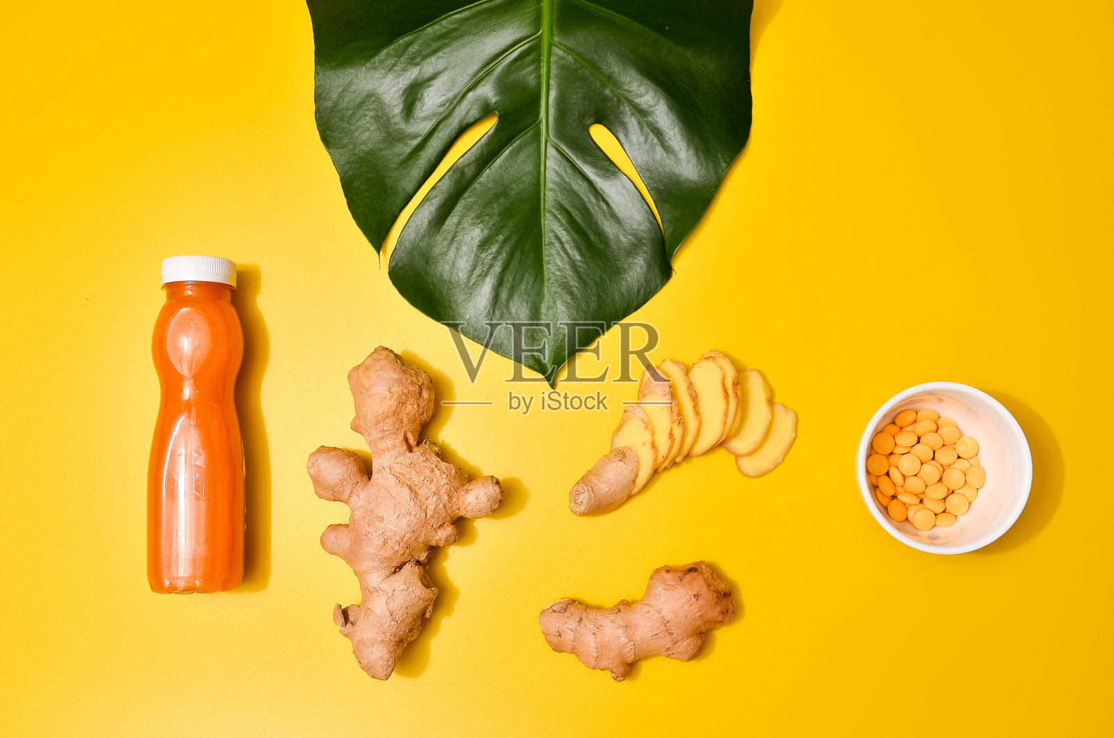 生姜在不同条件下:鲜、干根、片剂和切块植物上以淡黄色为背景。照片摄影图片