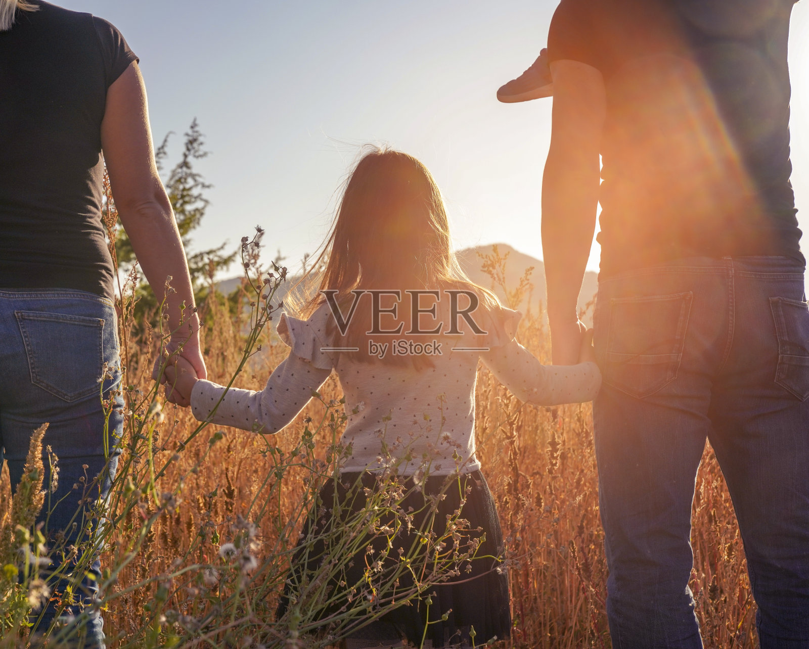 幸福的家庭:母亲，父亲，孩子女儿在夏天的日落照片摄影图片