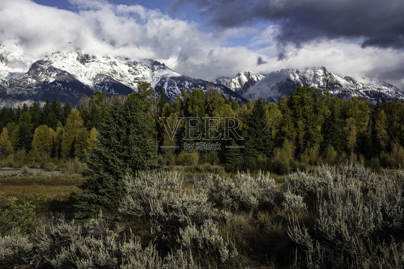 乌云笼罩着大提顿山脉的雪山。照片摄影图片