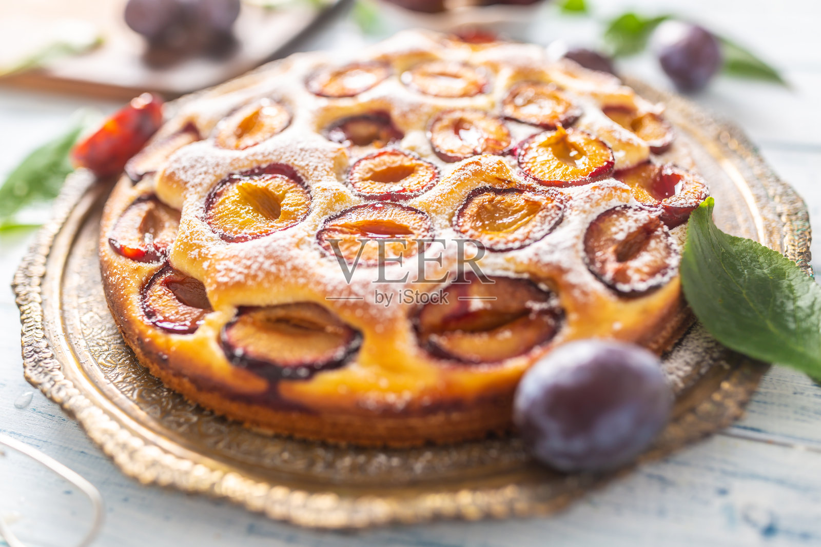 自制的葡萄干蛋糕在老式盘子在木桌上。糖粉梅子派照片摄影图片