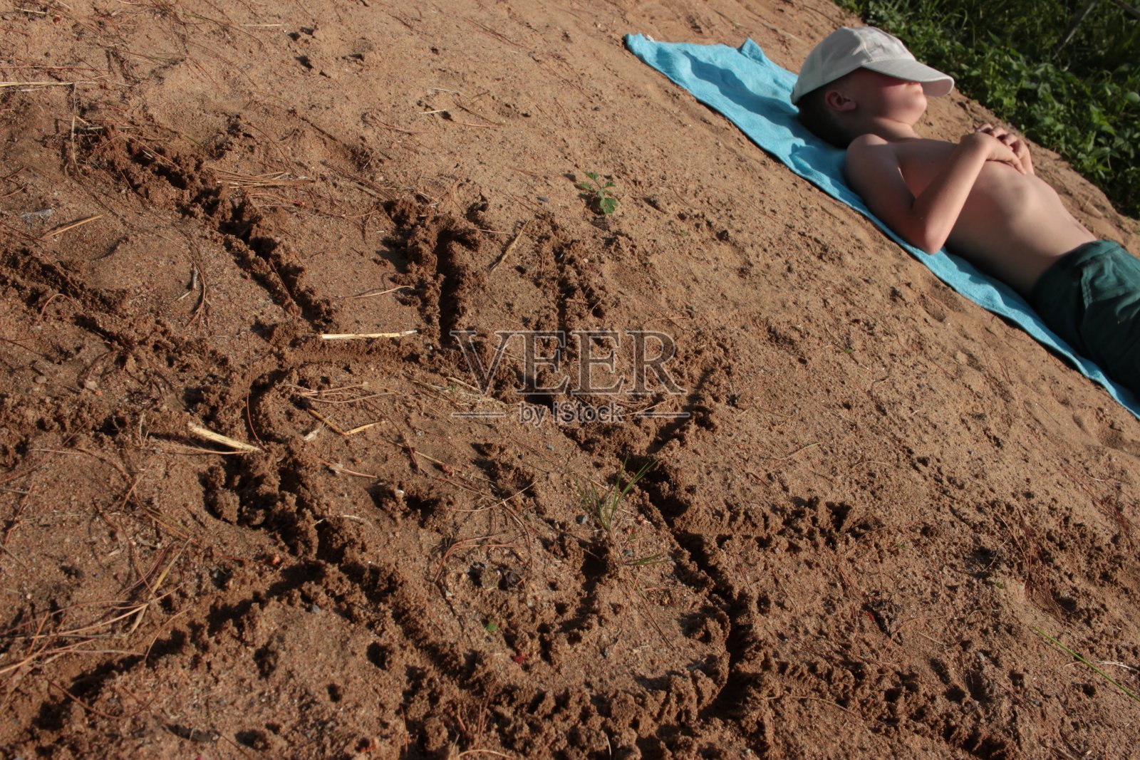 孩子们在沙滩上画太阳。照片摄影图片