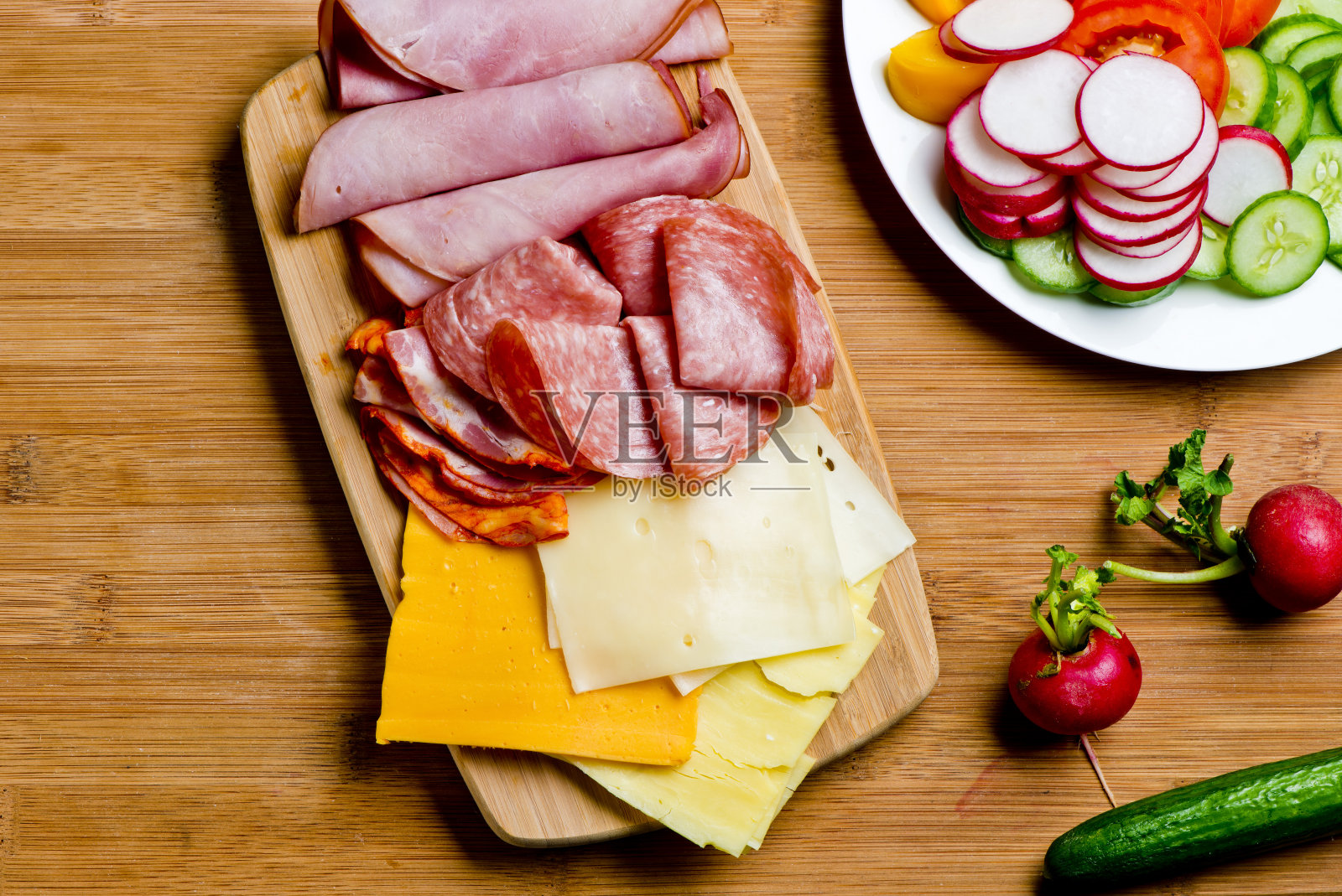 熟食或开胃菜拼盘与干腌肉，意大利腊肠，意大利熏火腿，西西里裂绿橄榄，卡拉马塔橄榄，樱桃祖传番茄，朝鲜蓟心，水牛奶酪，布里干酪，腌制烤蔬菜，烤面包。照片摄影图片