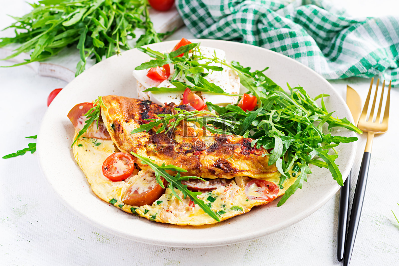 煎蛋卷配番茄、芝士和青菜。意式煎蛋饼。照片摄影图片