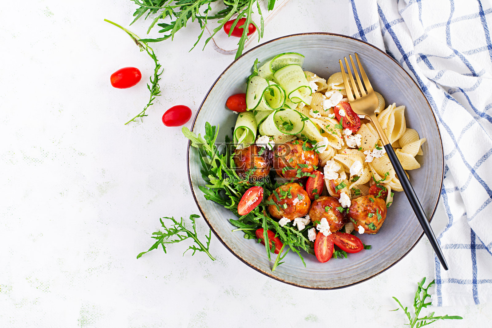 意大利面食。康奇利配肉丸，羊乳酪和沙拉，背景很亮。晚餐。顶视图,开销。慢食的概念照片摄影图片