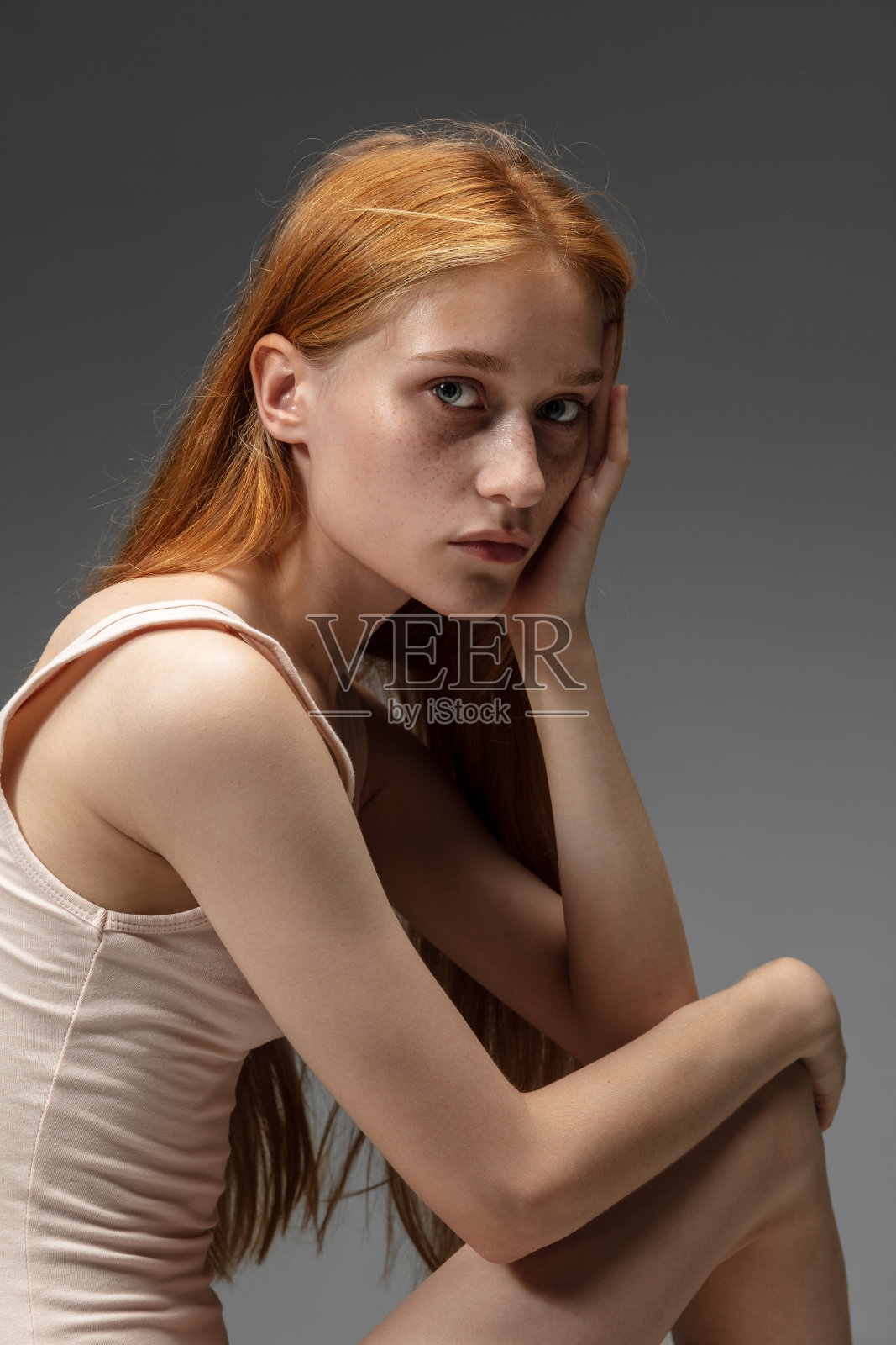 美丽的红发女人的肖像孤立在灰色的工作室背景。美丽、护肤、时尚、风格的概念照片摄影图片