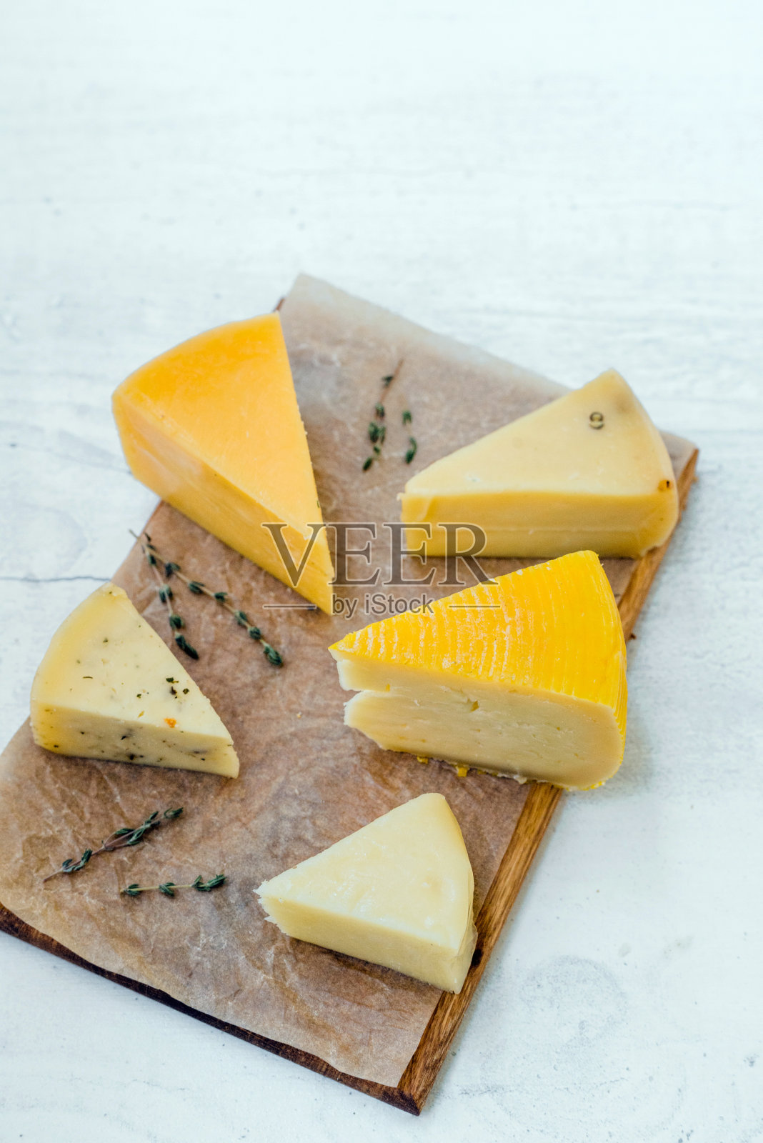 不同的新鲜奶酪放在木板上。俯视图照片摄影图片